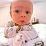 baby, infant, face, pajamas, bed, curious, wide_eyes, soft_lighting, ceiling_fan, indoors, child, cute, expression, closeup, portrait, lying_down, animal_print, blanket, room, skin