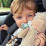 toddler, child, car_seat, pacifier, stuffed_animal, plush_toy, beads, safety_belt, blue_eyes, blond_hair, striped_shirt, indoors, seatbelt, cute, baby_accessory, car_interior, close_up, person, infant, holding