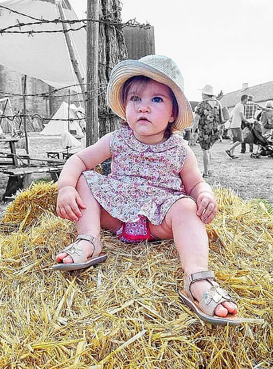 Emma a rejoint le concours — aidez-le/la à gagner de superbes lots ! baby, baby_toddler_clothing, cap, child, fashion_accessory, fun, grass, happy, hat, headwear, human_leg, landscape, pattern, people_in_nature, person, photograph, sitting, sky, sun_hat, tire
