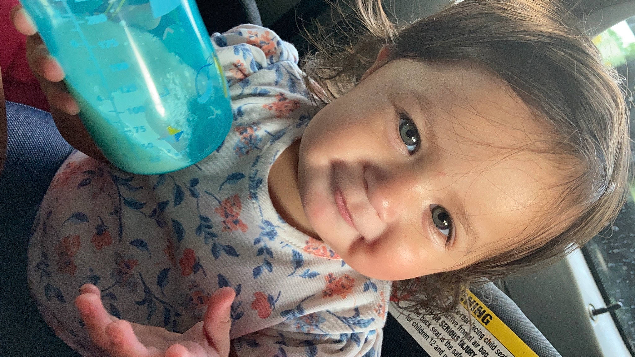 Delaney is registered to the contest to win money with this photo: baby, blue, cheek, child, drinkware, eye, eyelash, face, facial_expression, happy, iris, lip, mouth, nose, person, plastic_bottle, skin, smile, tableware, toddler