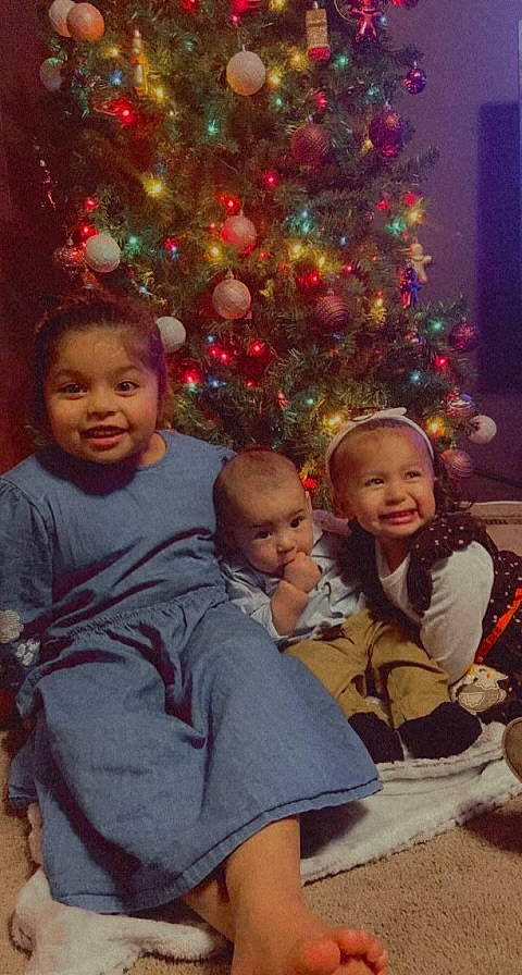 Janayle joined the competition — help win amazing prizes! beauty, christmas_decoration, christmas_ornament, christmas_tree, face, facial_expression, fun, happy, head, holiday_ornament, human_body, interaction, joy, leaf, organ, ornament, person, smile, standing, toddler