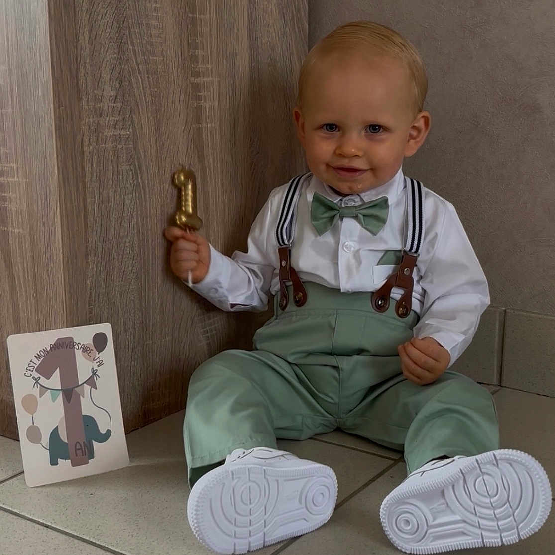 Lewen a rejoint le concours — aidez-le/la à gagner de superbes lots ! baby, balloon, birthday, bowtie, boy, card, celebration, child, cute, face, floor, green_pants, indoor, number_one, portrait, smile, suspenders, tile, white_shirt, white_shoes