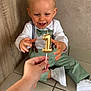 birthday, bow_tie, boy, candle, celebration, child, cute, green_pants, hand, happy, indoor, number_one, party, person, portrait, smiling, suspenders, tile_floor, toddler, white_shoes