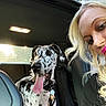 backseat, blonde_hair, candid, car, collar, dog, great_dane, happy, human, indoor, leather_seat, pet, pink_lipstick, portrait, seatbelt, sunlight, tongue_out, travel, window, woman