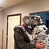Huckleberry Hound is registered to the contest to win money with this photo: affection, box, brown_hoodie, casual_clothing, collar, dog, door, embrace, happy, head, hug, indoor, interaction, large_dog, paw, person, smile, spot, wall, wooden_stick