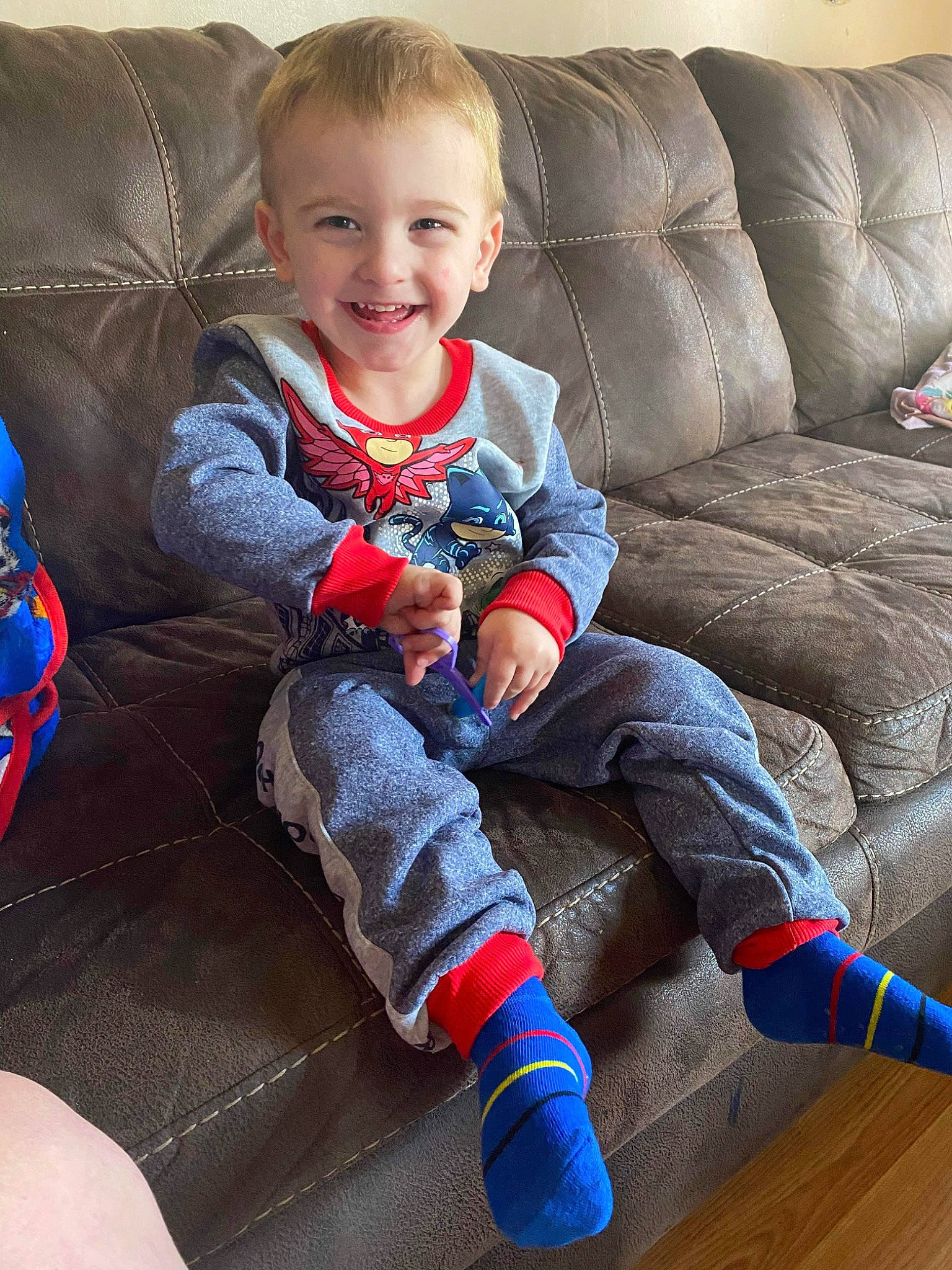 Gregory is registered to the contest to win money with this photo: baby_toddler_clothing, comfort, couch, electric_blue, eye, face, finger, furniture, head, joy, knee, lap, leg, living_room, person, sleeve, smile, sock, textile, thigh