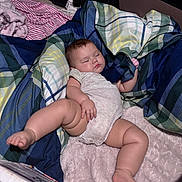 Desiree is registered to the contest to win money with this photo: baby, sleeping, blanket, plaid, bedding, infant, child, soft, cozy, peaceful, hand, leg, cute, indoors, resting, person, skin, foot, onepiece, nap