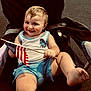 american_flag, barefoot, celebration, chair, child, cute, daylight, flag, fun, happy, outdoor, patriotic, person, shorts, sitting, smiling, summer, tank_top, toddler, young_child