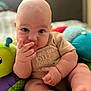 Jace is registered to the contest to win money with this photo: baby, child, infant, toy, colorful, soft_toy, sitting, curious, hand, fingers, face, portrait, indoor, cute, clothing, expression, skin, comfort, closeup, play