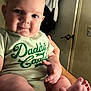 Jace joined the competition — help win amazing prizes! baby, child, infant, smiling, onesie, green_clothing, indoor, hand, feet, face, person, cute, cheeks, expression, skin, door, clothes, background, holding, closeup