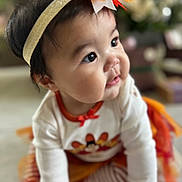 Isabella Rose is registered to the contest to win money with this photo: baby, child, crawling, headband, autumn, colorful, clothing, cute, indoor, face, cheeks, eyes, festive, soft_focus, toddler, person, playful, warm_colors, orange, white