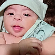 Isaiah is registered to the contest to win money with this photo: baby, infant, towel, hood, dinosaur, cute, skin, hand, face, expression, child, newborn, wrapped, soft, blanket, adorable, portrait, indoors, closeup, playful