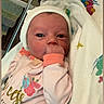 Brooklynn joined the competition — help win amazing prizes! newborn, baby, infant, hospital, crib, blanket, hat, pink_clothing, mitten, hand, face, portrait, lying_down, indoors, bedding, colorful, medical_setting, awake, sucking_hand, closeup