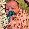 baby, infant, child, portrait, face, eyes, pacifier, blanket, swaddle, strawberry, pink, green, polka_dots, lying_down, cozy, indoors, bed, close_up, relaxed, photography