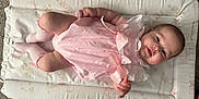 Bonnie joined the competition — help win amazing prizes! baby, infant, pink_dress, socks, changing_mat, carpet, lying_down, smiling, face, skin, cute, child, young, indoors, soft_lighting, comfortable, adorable, person, human, closeup