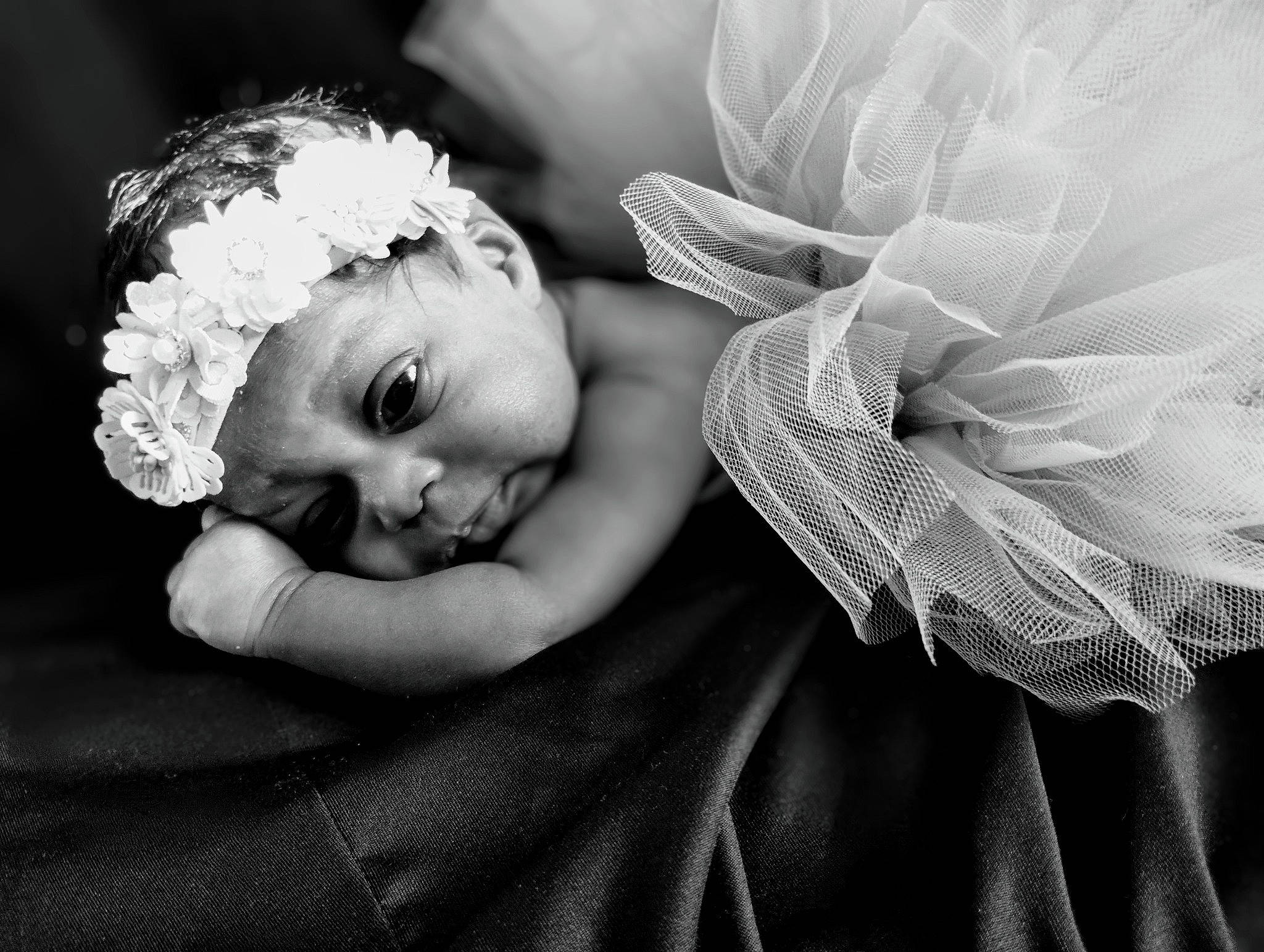 Joanna is registered to the contest to win money with this photo: arm, baby, beauty, black_and_white, child, close_up, comfort, eye, flash_photography, gesture, happy, headpiece, iris, monochrome, monochrome_photography, person, petal, smile, style, toddler
