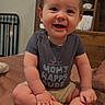 baby, infant, child, smiling, sitting, portrait, indoors, bedroom, nursery, crib, bed, wooden_furniture, brown, gray_shirt, shorts, barefoot, happy, face, family, photography