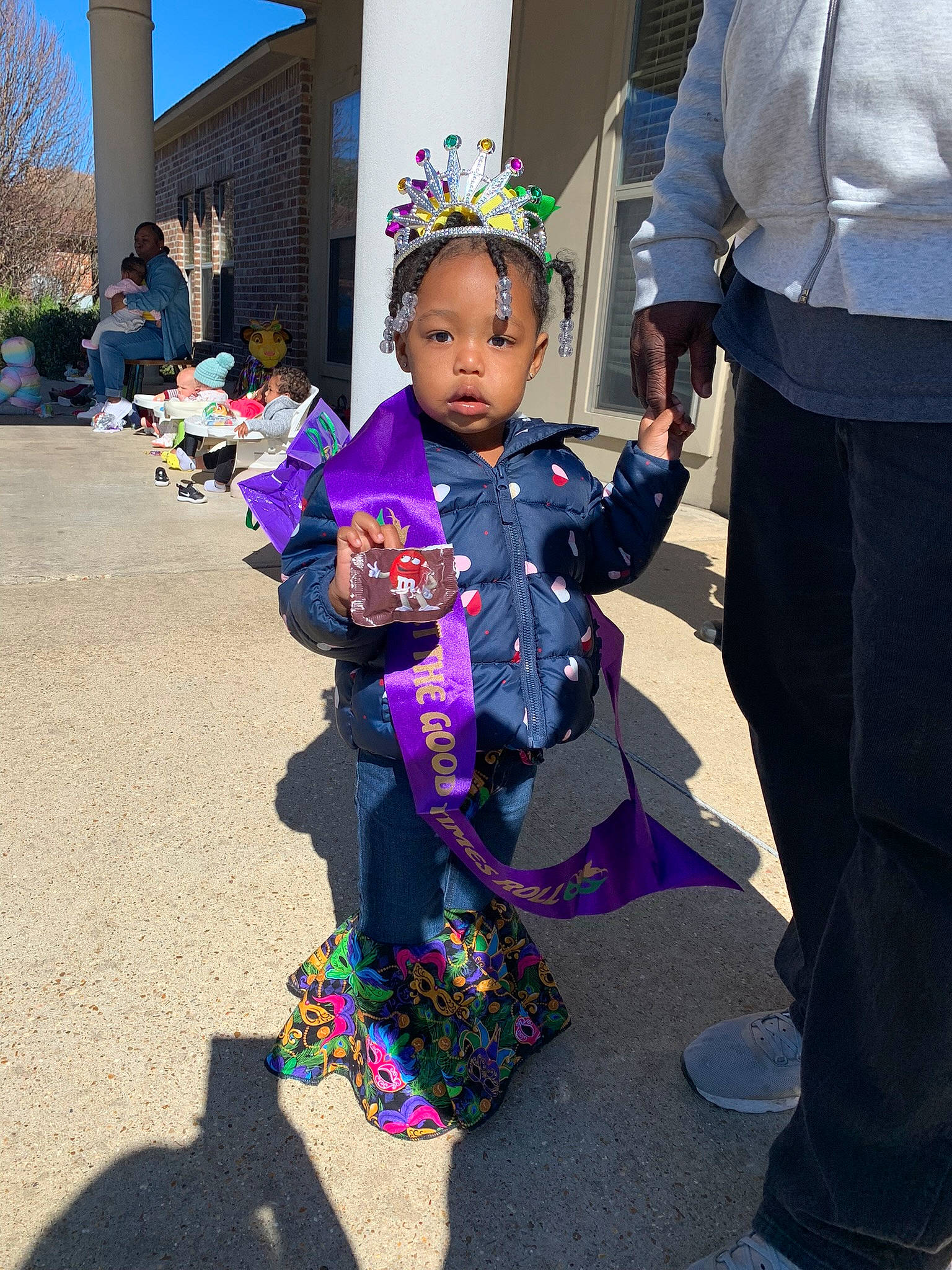 Daenerys is registered to the contest to win money with this photo: baby, child, costume, costume_hat, event, fun, happy, holiday, leisure, magenta, party_supply, person, public_event, purple, recreation, sandal, street, toddler, tradition, tree