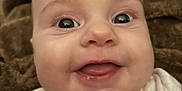 Madilynn is registered to the contest to win money with this photo: baby, smiling, closeup, face, infant, tongue, white_clothing, blanket, happy, cute, child, portrait, skin, eyes, young, head, expression, indoors, cozy, soft