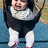 Marc is registered to the contest to win money with this photo: baby, child, swing, playground, outdoor, smiling, happy, clothing, sock, seat, rubber_surface, sunlight, shadow, park, person, infant, black_swing, green_grass, metal_chains, casual_wear