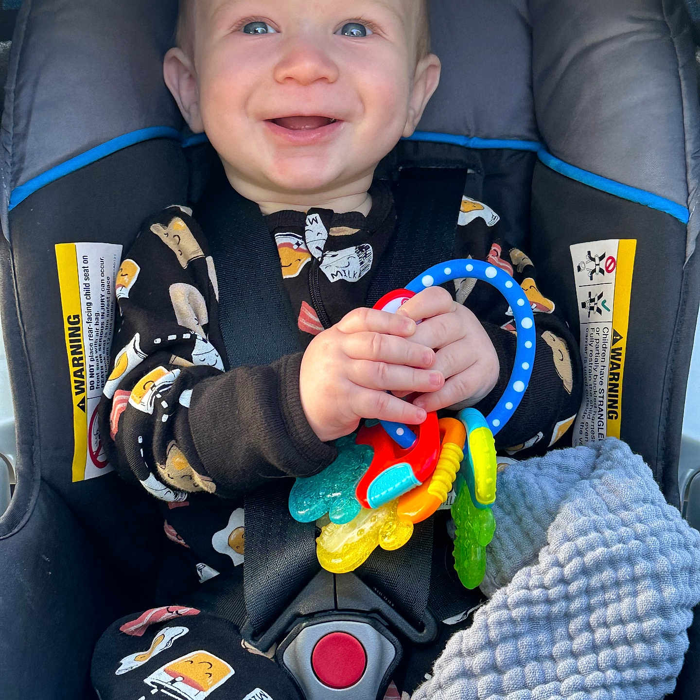 Jacob is registered to the contest to win money with this photo: baby, bodypart, car, car_interior, carseat, clothing, coat, face, finger, glove, hand, happy, head, person, photography, portrait, smile, toy, transportation, vehicle