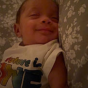 Rodney joined the competition — help win amazing prizes! baby, smiling, sleeping, pillow, floral_pattern, shirt, colorful_text, arm, infant, cozy, bed, blanket, closeup, child, peaceful, indoors, portrait, resting, cute, young