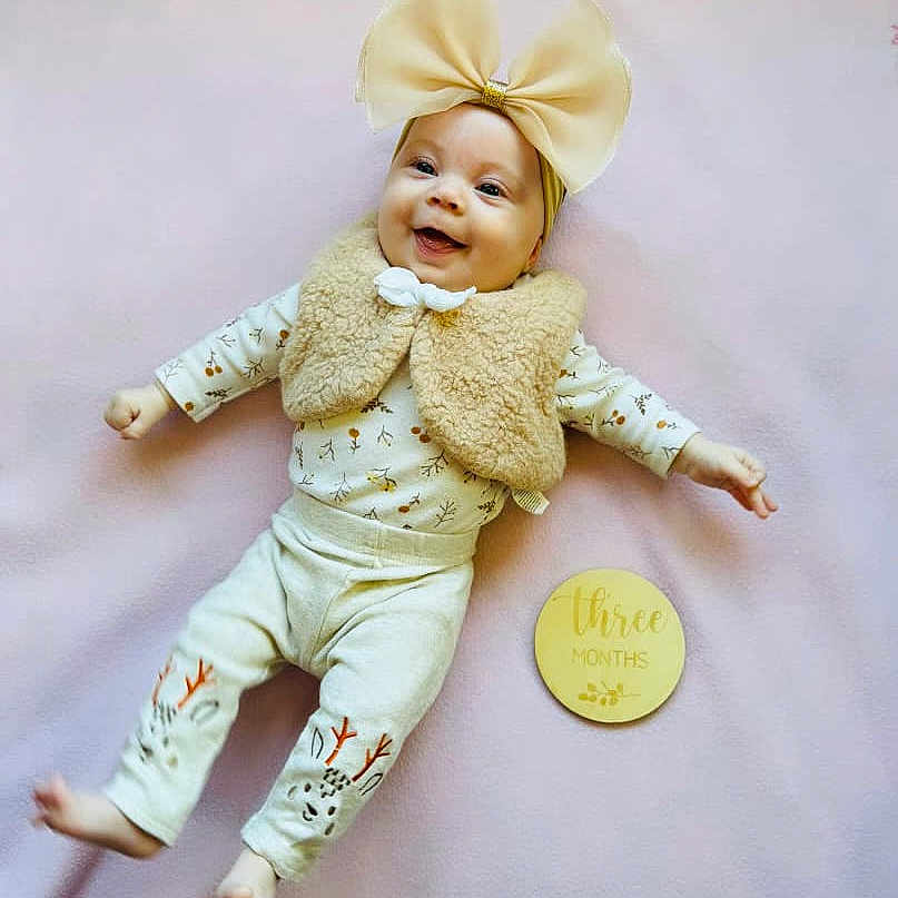 Nova joined the competition — help win amazing prizes! baby, babylaughing, bonnet, clothing, costume, face, happy, hat, head, pants, person, photography, portrait, sitting, sleeve, smile