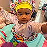 Autumn is registered to the contest to win money with this photo: baby, child, indoor, bonnet, colorful, toy, walker, face, person, curious, clothing, infant, play, furniture, floor, expression, headwear, home, young, activity