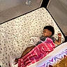 Autumn is registered to the contest to win money with this photo: baby, sleeping, pacifier, blanket, crib, playpen, animal_print, floor, wood_floor, child, infant, rest, toddler, cozy, indoor, soft, quiet, peaceful, comfort, nursery