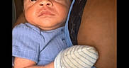 Jakaidens is registered to the contest to win money with this photo: arm, baby, blue_clothing, bonding, care, child, close_up, cute, expression, family, holding, indoor, infant, mittens, newborn, person, portrait, skin, striped_pants, young_child