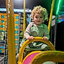 Ilinca is registered to the contest to win money with this photo: activity, child, clothing, colorful, curly_hair, entertainment, fun, hands, indoor, netting, overalls, person, play_structure, playground, recreation, smile, soft_lighting, toddler, yellow, young_child