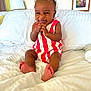 Ropyr joined the competition — help win amazing prizes! baby, child, smiling, bed, white_bedding, red_stripes, romper, indoor, lamp, framed_art, flower_picture, happy, cute, furniture, home, portrait, sitting, skin, foot, infant