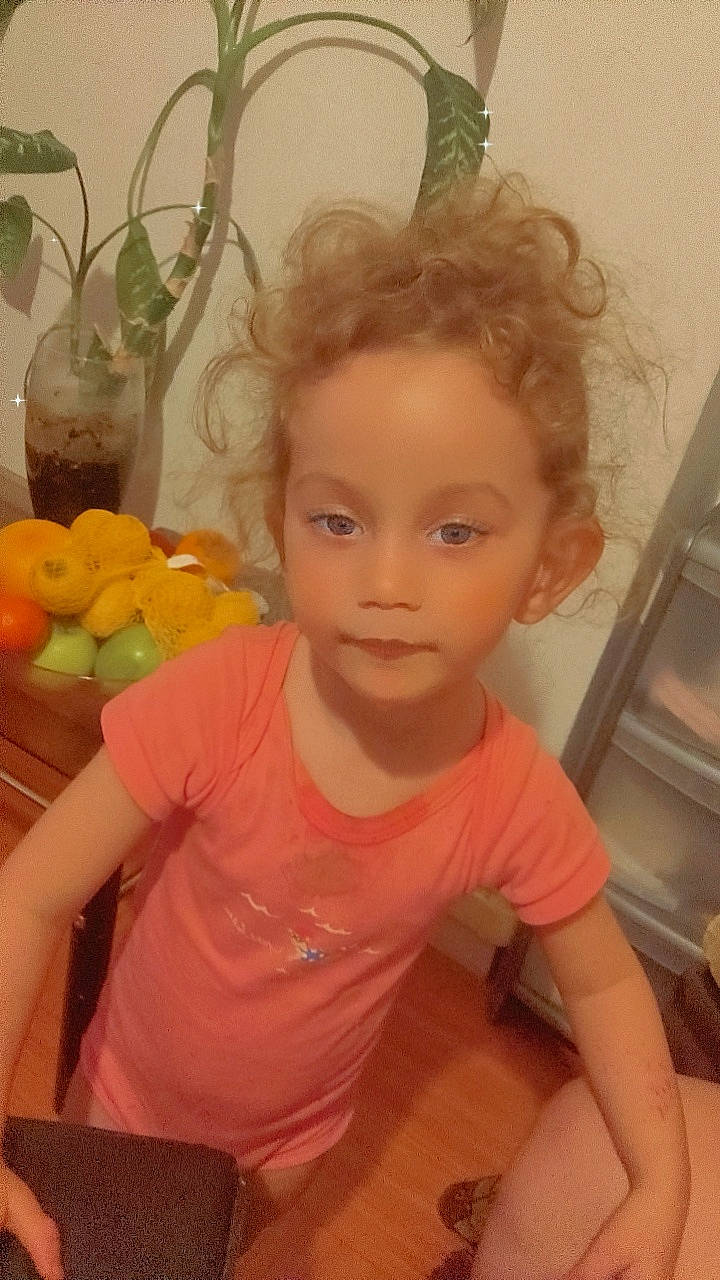 Aya participe au concours pour gagner de l'argent avec cette photo : apple, blond, child, citrus, eyelash, fruit, fun, hair, happy, local_food, natural_foods, person, produce, room, sitting, smile, superfood, t_shirt, tangerine, toddler