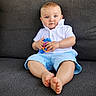 Owen joined the competition — help win amazing prizes! baby, child, blue_eyes, white_shirt, light_blue_shorts, toys, colorful, sitting, couch, indoor, barefoot, cute, portrait, young_child, hands, feet, comfortable, expression, texture, clothing