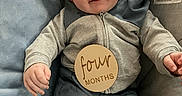 Owen joined the competition — help win amazing prizes! baby, child, infant, smiling, seated, clothing, blue_pillow, cushion, wooden_sign, four_months, face, head, hands, legs, indoor, cozy, comfortable, cute, portrait, person