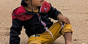 Alexis a rejoint le concours — aidez-le/la à gagner de superbes lots ! toddler, child, beach, sand, stick, barefoot, hat, jacket, pants, cloudy_sky, outdoor, seaside, casual_clothing, curious, sitting, nature, daytime, young_child, exploring, relaxed