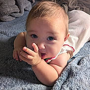 Eleanor joined the competition — help win amazing prizes! baby, blanket, blue_eyes, child, closeup, clothing, cozy, curious, cute, face, hand, indoors, infant, lying_down, portrait, resting, skin, sleepwear, soft_texture, toddler