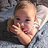 baby, blanket, blue_eyes, child, closeup, clothing, cozy, curious, cute, face, hand, indoors, infant, lying_down, portrait, resting, skin, sleepwear, soft_texture, toddler