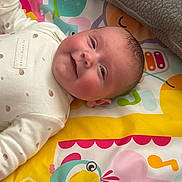 Riley is registered to the contest to win money with this photo: baby, infant, smiling, play_mat, colorful, blanket, cute, child, lying_down, indoors, clothing, patterned, face, head, happy, person, young_child, fisherprice, toy, soft_toys