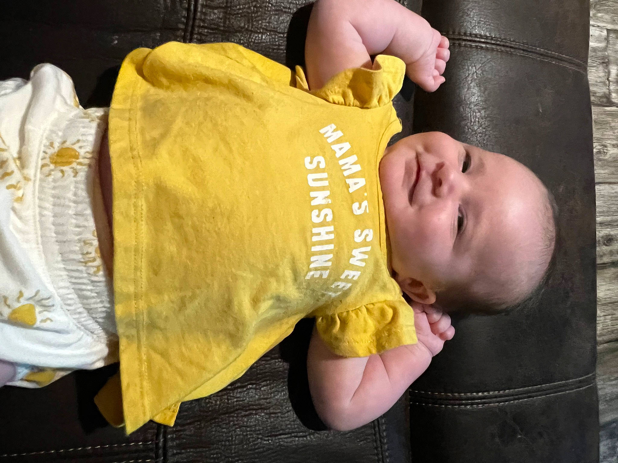 Delylah is registered to the contest to win money with this photo: baby, baby_products, baby_safety, baby_toddler_clothing, cheek, child, comfort, elbow, event, finger, happy, joy, person, product, sitting, sleeve, t_shirt, thumb, toddler, wood