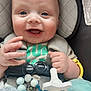 baby, smiling, car_seat, pacifier, toy, infant, child, happy, face, hand, close_up, seat_belt, clothing, beads, indoor, cute, skin, head, expression, sitting