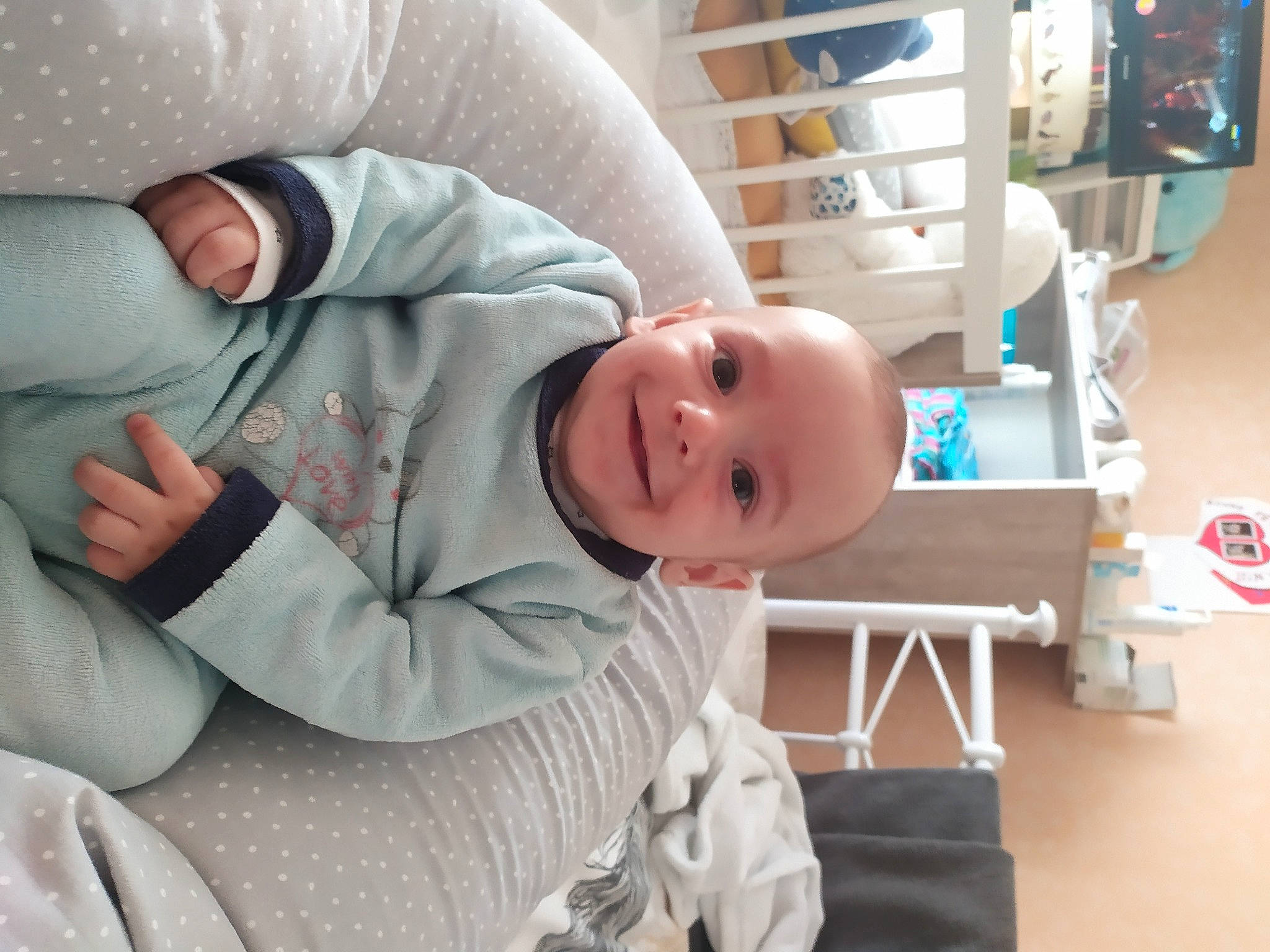 Lyam participe au concours pour gagner de l'argent avec cette photo : arm, baby, baby_products, baby_safety, baby_sleeping, baby_toddler_clothing, bookcase, box, child, comfort, gesture, hat, joy, linens, person, room, shelf, shelving, sitting, sleeve