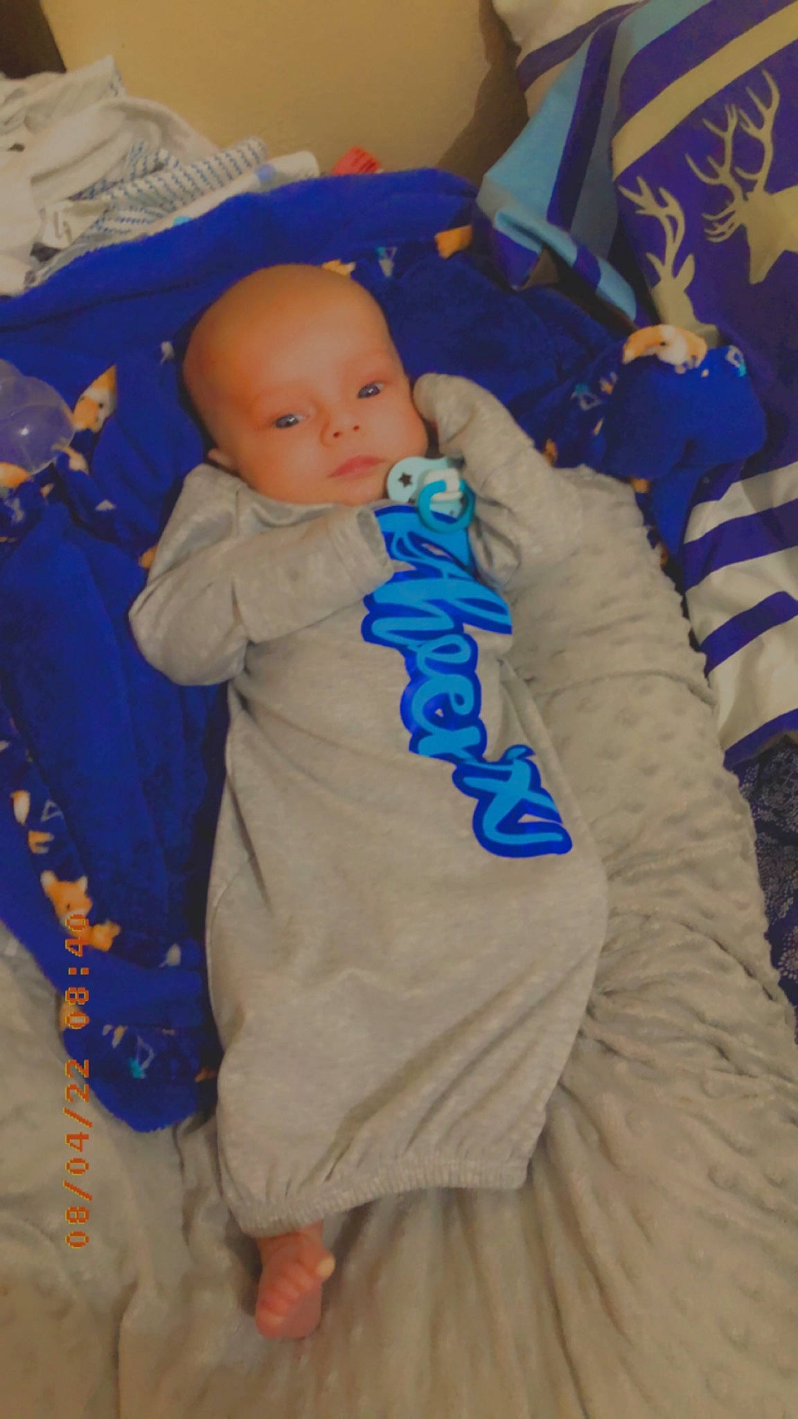 Phoenix is registered to the contest to win money with this photo: azure, baby, baby_products, baby_toddler_clothing, blue, child, comfort, electric_blue, event, finger, fun, happy, interaction, linens, person, purple, room, sitting, skin, textile