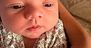 Kinsley joined the competition — help win amazing prizes! baby, infant, close_up, face, skin, arm, hand, clothing, floral_pattern, person, newborn, cute, child, portrait, soft_lighting, expression, indoor, holding, gentle, peaceful