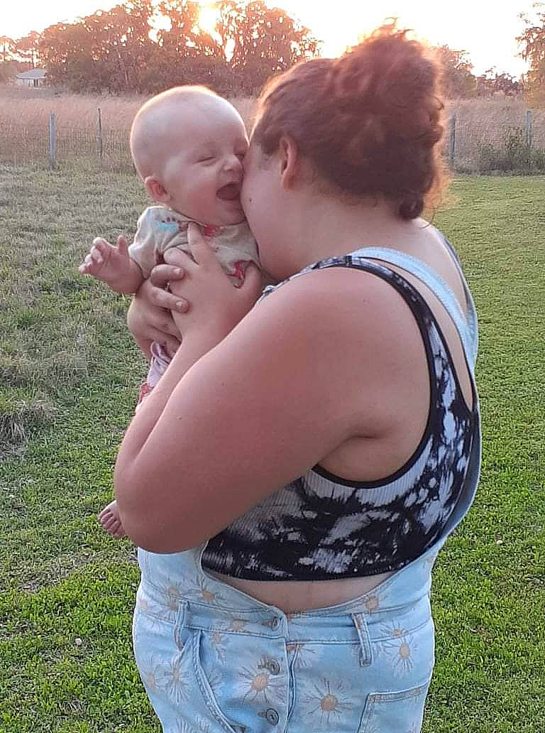 Gracie joined the competition — help win amazing prizes! arm, baby, chest, clothing, gesture, grass, happy, jeans, joint, people_in_nature, person, photograph, plant, shoulder, sky, smile, standing, summer, tree, trunk