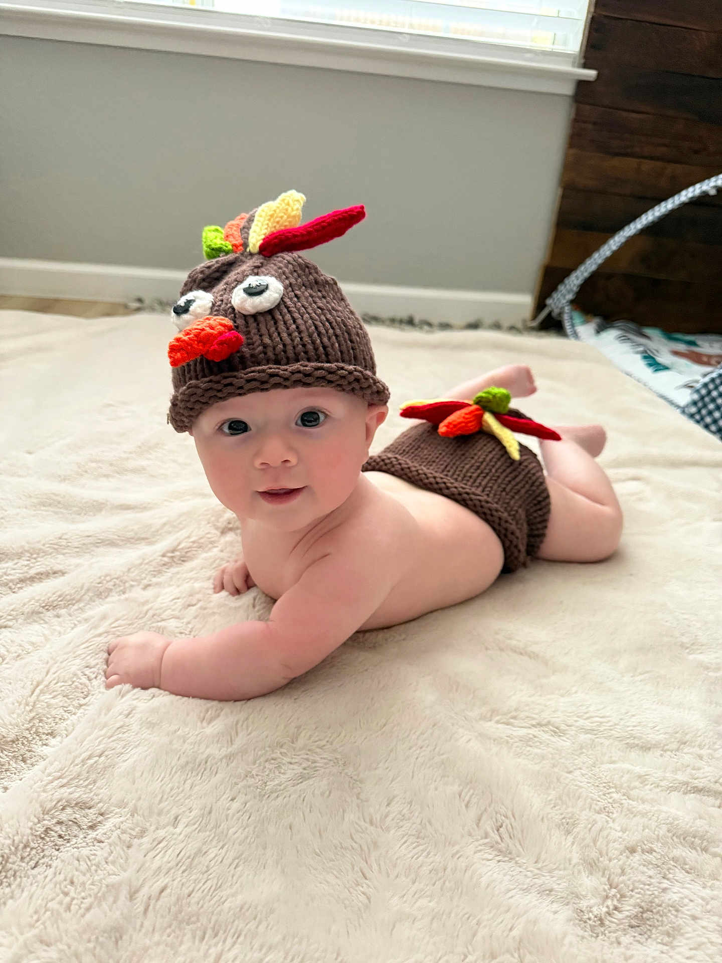 Maddox joined the competition — help win amazing prizes! baby, child, infant, knitted_hat, turkey_hat, diaper_cover, blanket, floor, indoor, cute, soft_texture, window, natural_light, baby_clothing, face, smiling, lying_down, headwear, plush, room