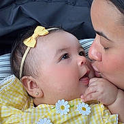 Paulina joined the competition — help win amazing prizes! baby, infant, parent, kiss, closeup, yellow_dress, headband, bow, gingham, flower_applique, earring, hand, eyes, smile, car_seat, seat_headrest, skin, affection, family, portrait