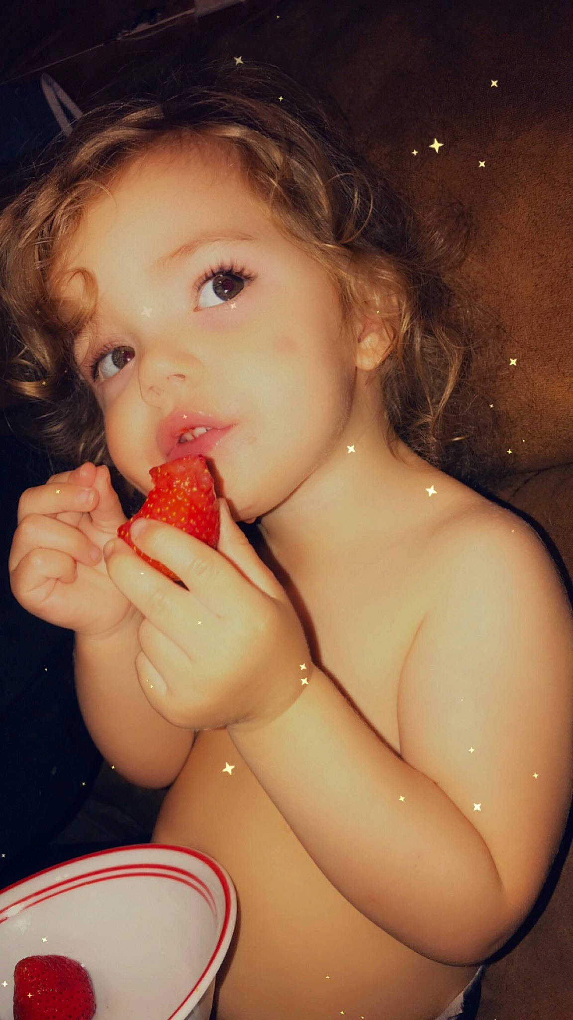 Madelyn is registered to the contest to win money with this photo: bathing, brown_hair, chest, eating, finger, fruit, fun, hair_accessory, hairstyle, hand, lip, nail, neck, organ, person, produce, skin, strawberry, sweetness, taste