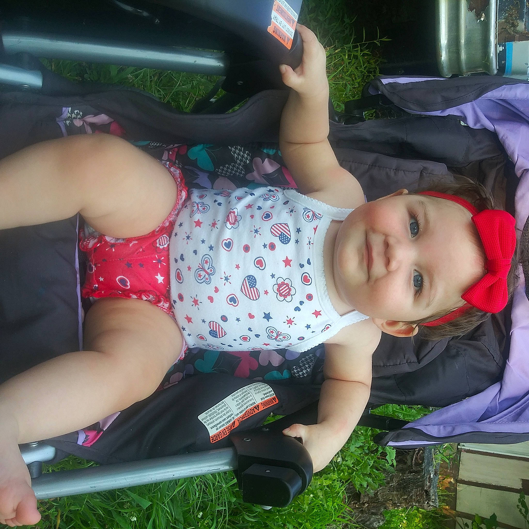Lilliona is registered to the contest to win money with this photo: auto_part, baby, baby_toddler_clothing, chest, child, cool, elbow, fun, grass, headwear, human_body, human_leg, joy, lap, leisure, pattern, person, sitting, smile, summer