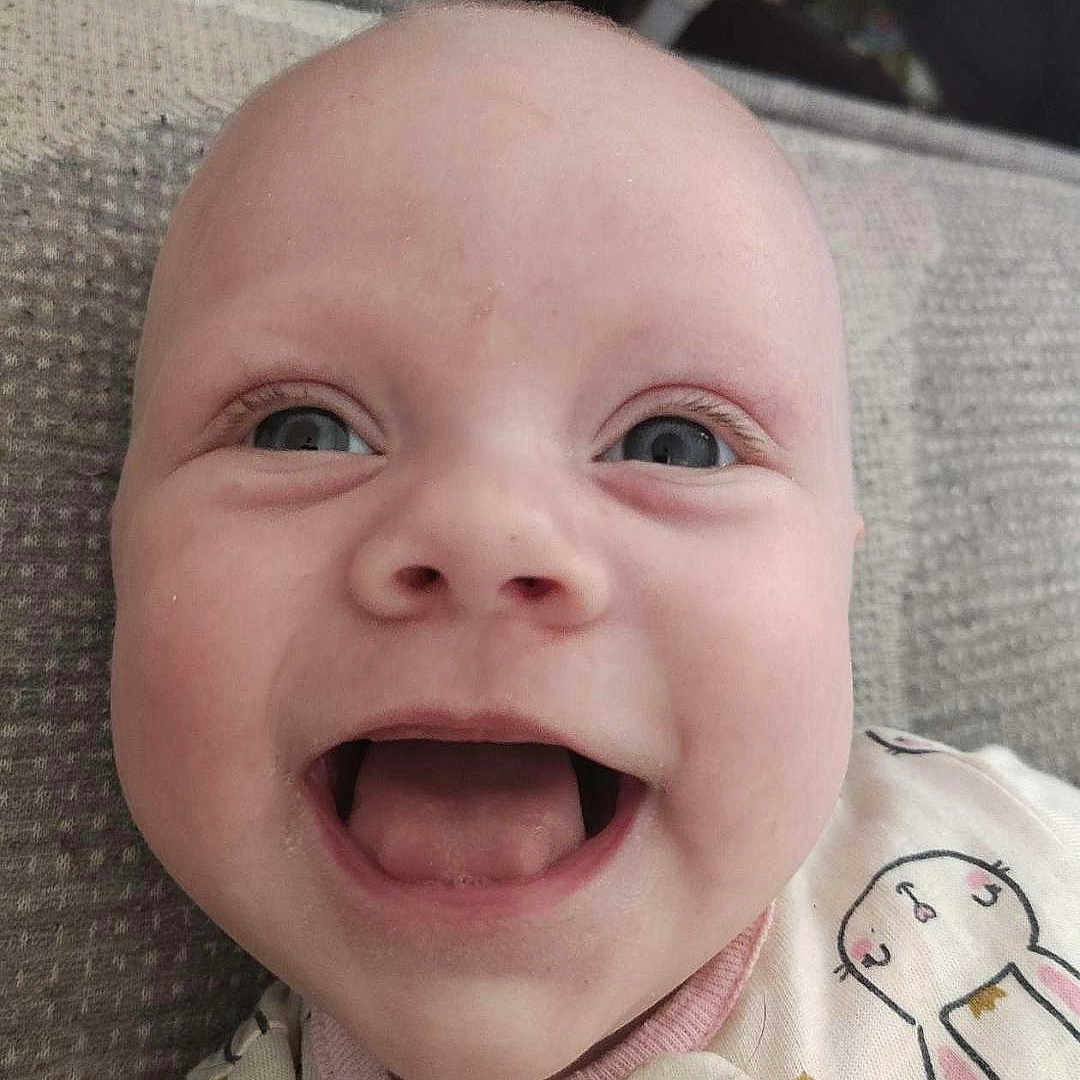Ruby-Grace is registered to the contest to win money with this photo: baby, babylaughing, bodypart, clothing, coat, cushion, face, furniture, happy, head, homedecor, laughing, mouth, newborn, person, photography, portrait, selfie, smile, teeth